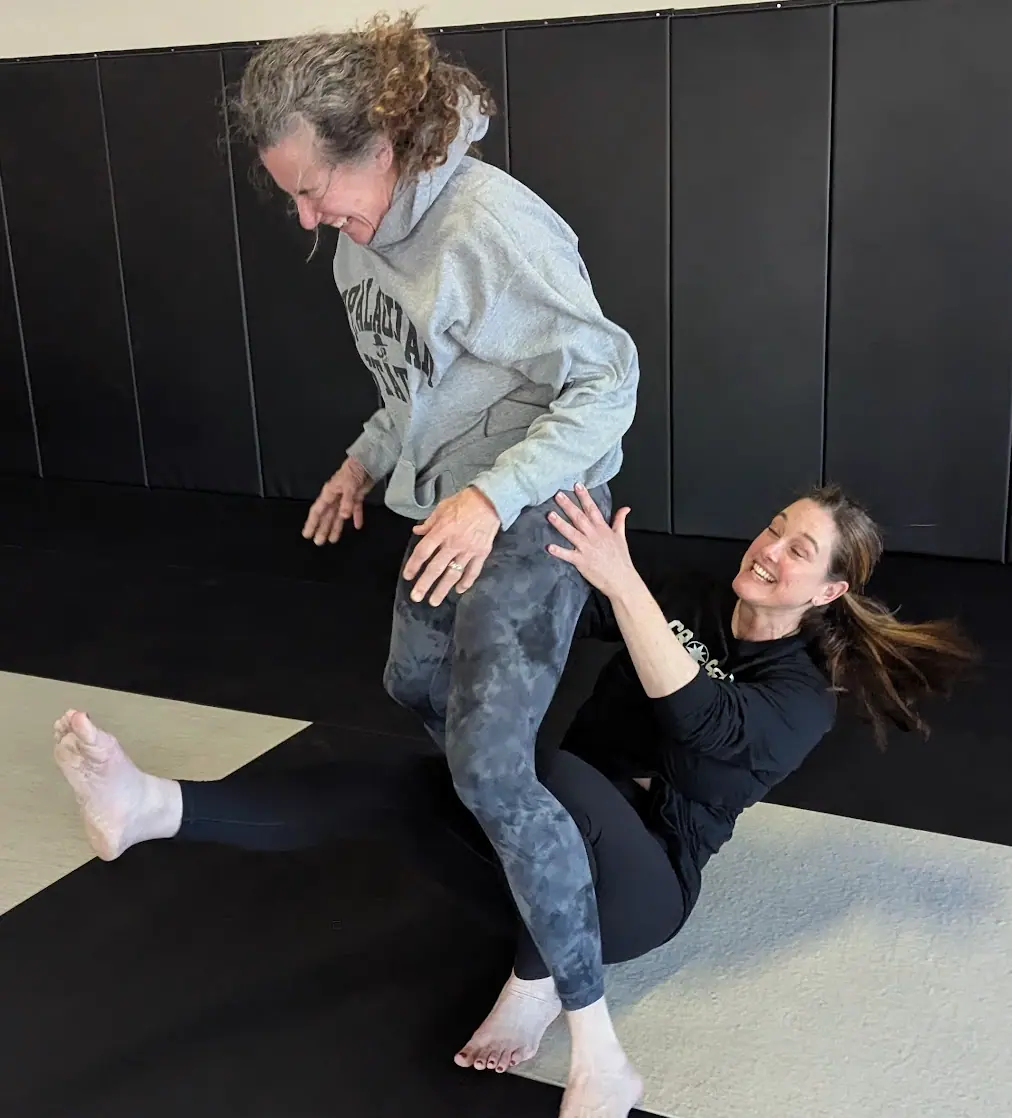Women practicing jiu-jitsu and self-defense techniques at CrossFit Coordinate community event in Cary NC