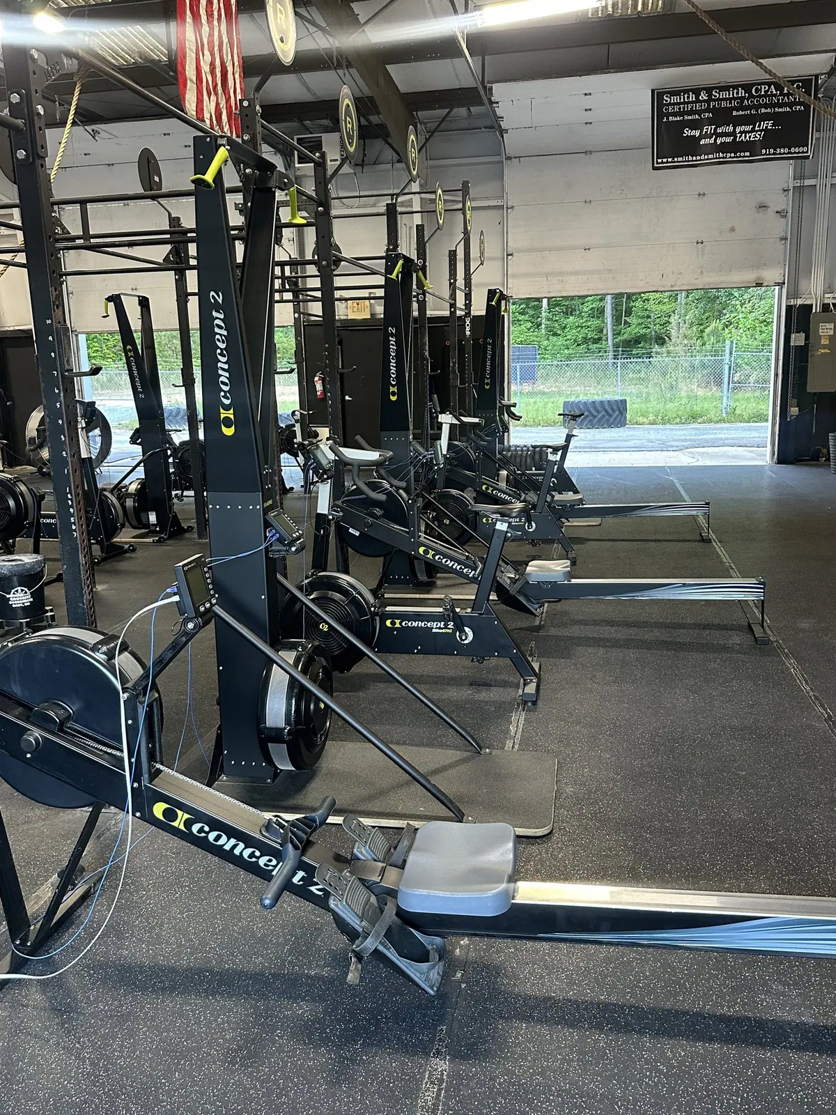 Row of Concept2 rowers, ski ergs and bike ergs lined up on the floor of CrossFit Coordinate before the Ergathlon starts