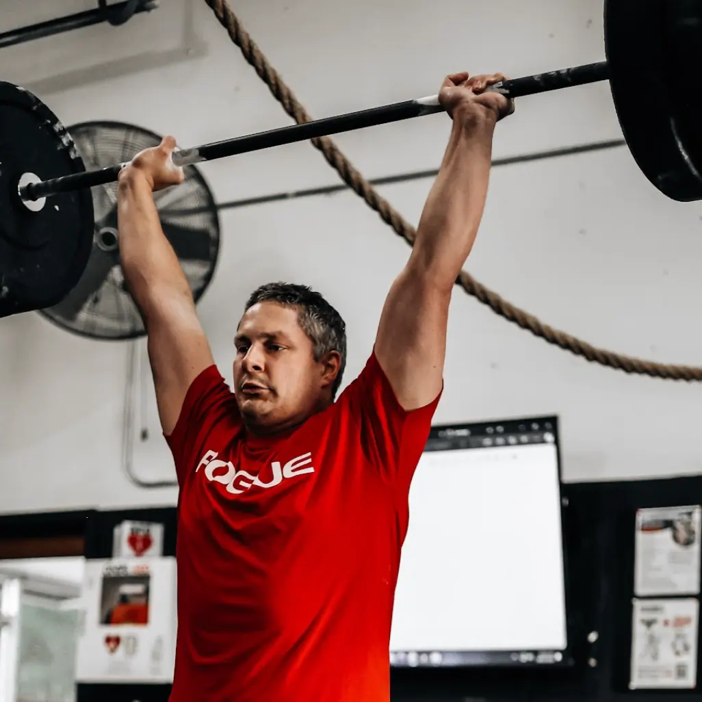 Patrick Williams locking out a clean and jerk during a CrossFit class at CrossFit Coordinate in Cary, NC